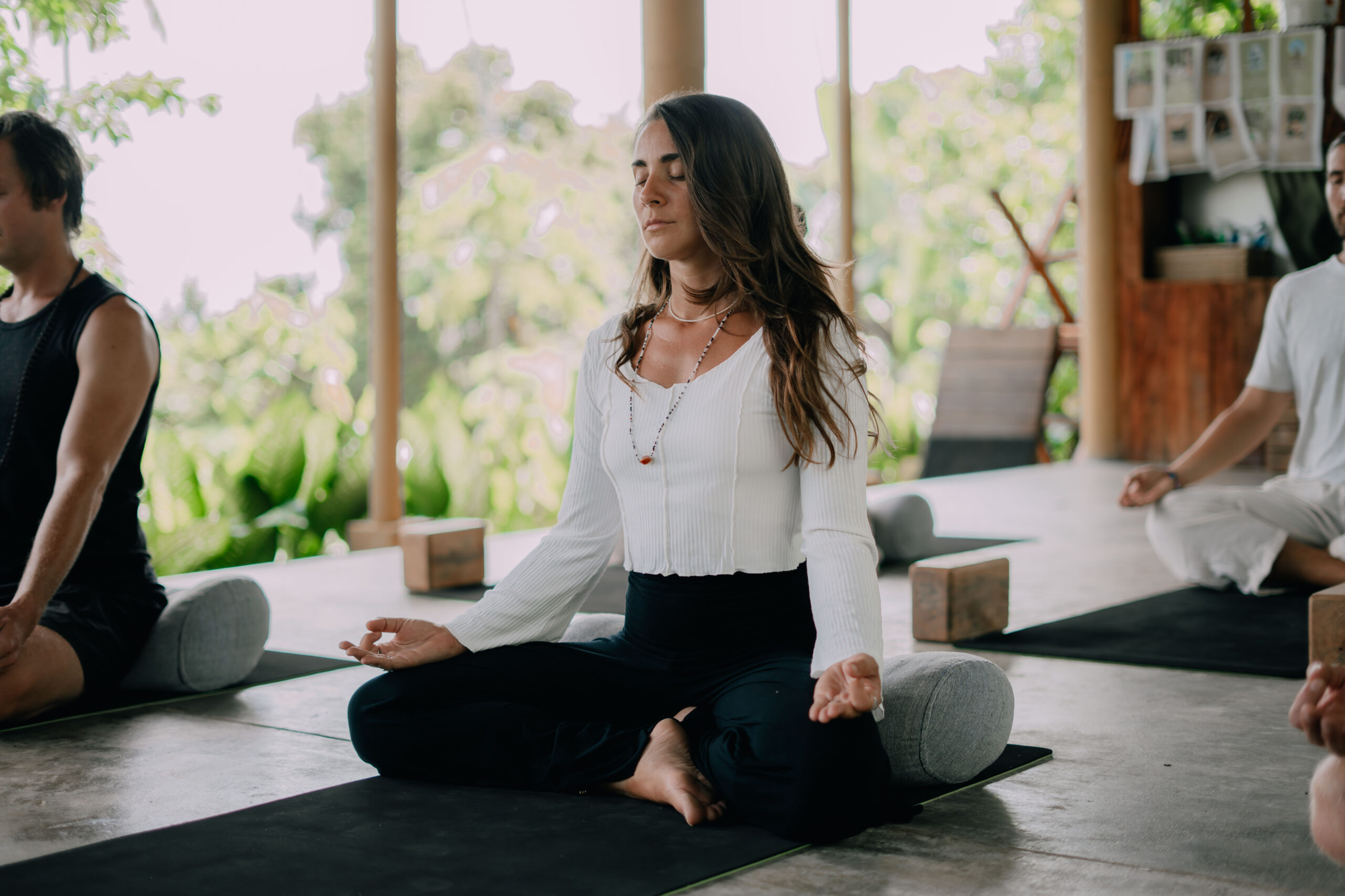 woman wearing black shirt sitting on green yoga mat